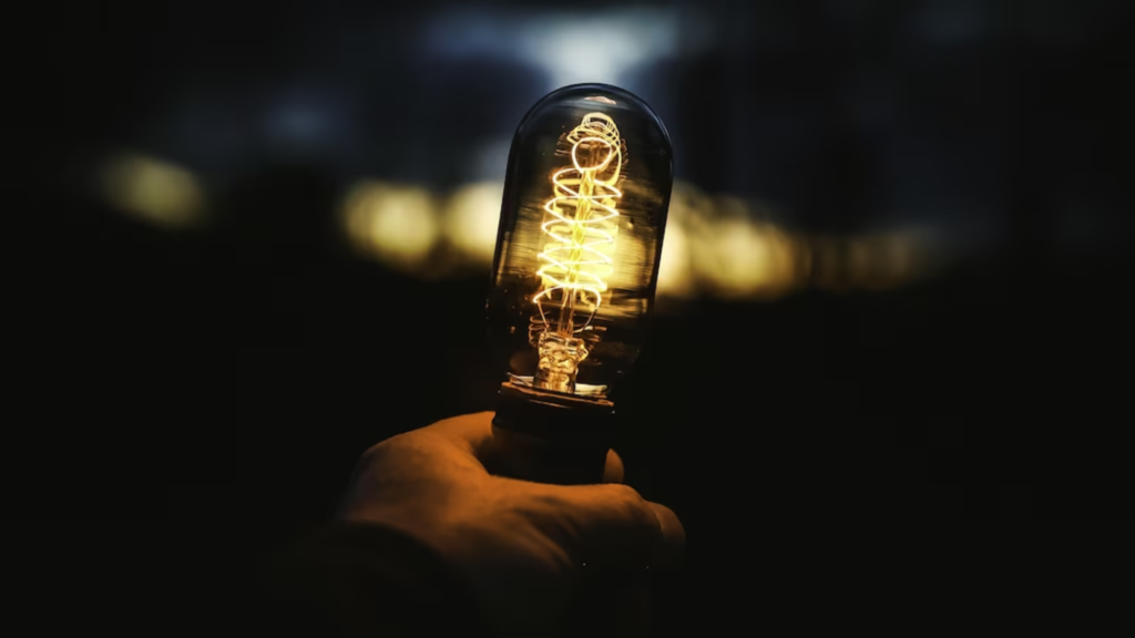 mão segurando uma lâmpada, representando uma soluçao